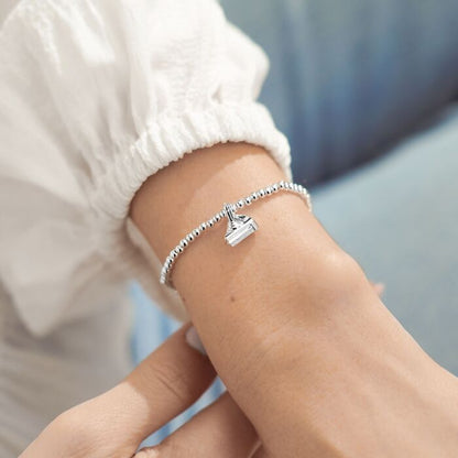 Silver-plated stretch beaded bracelet with cake shaped charm