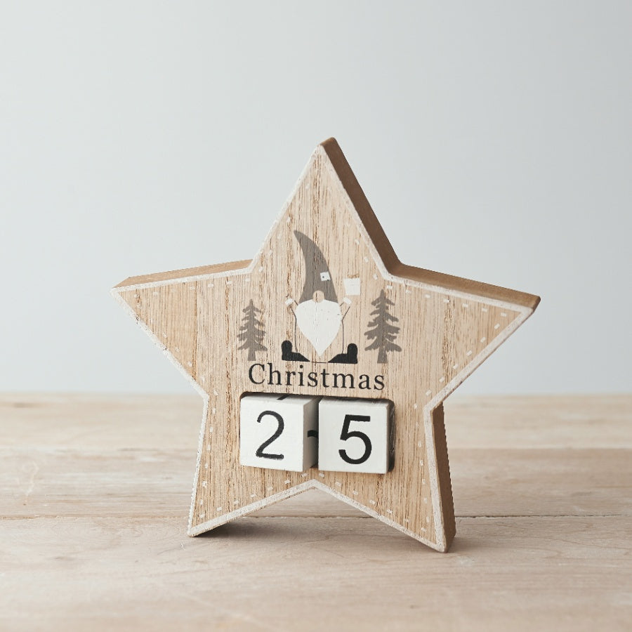 A wooden star-shaped Christmas countdown calendar featuring a printed grey and white gonk and moveable number blocks.