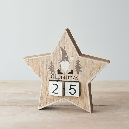 A wooden star-shaped Christmas countdown calendar featuring a printed grey and white gonk and moveable number blocks.