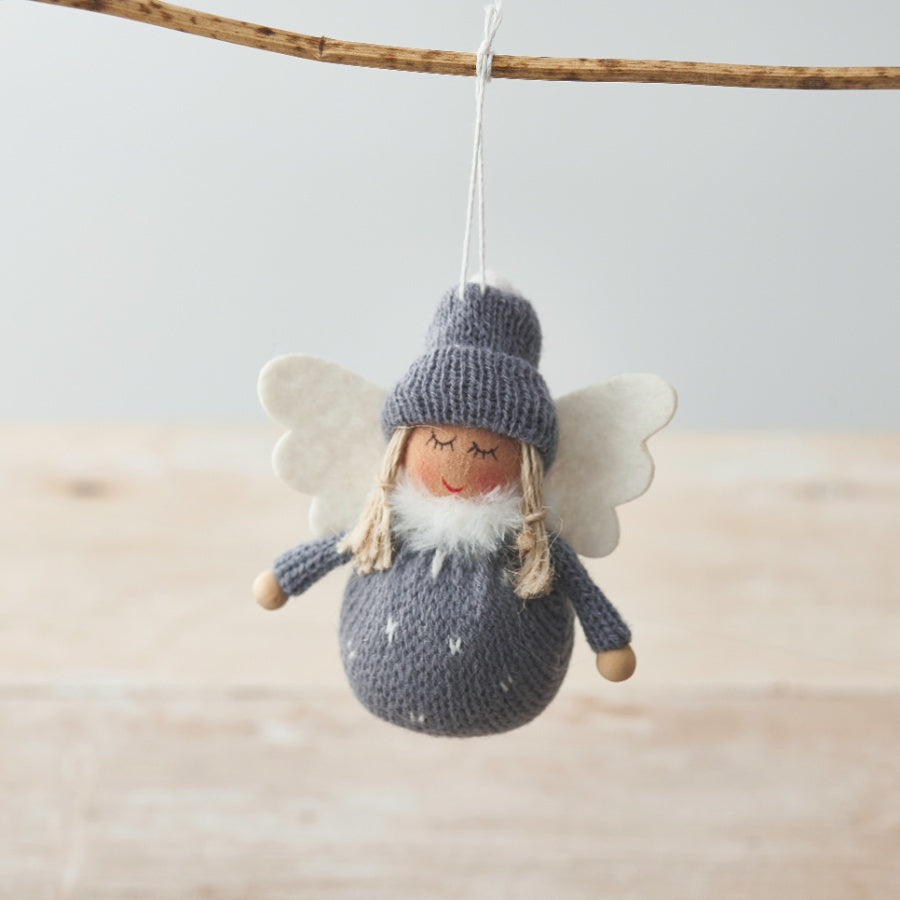 Knitted fabric angel decoration with spotty body, white wings and a woolly hat.