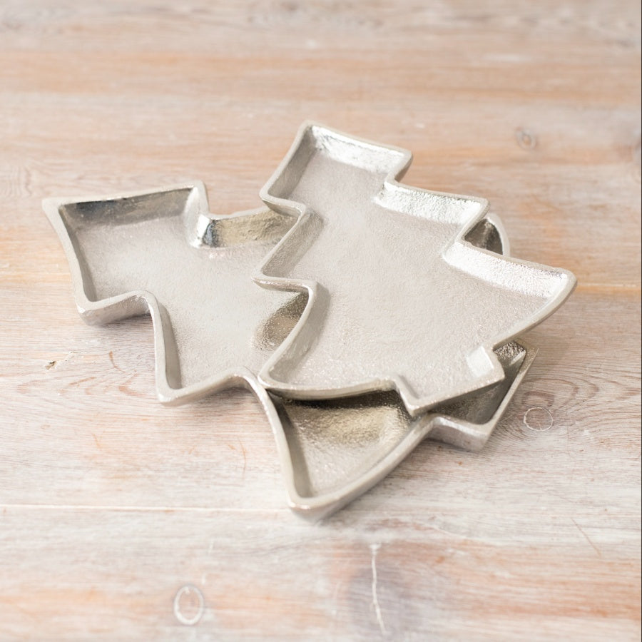 Decorative silver-coloured trays shaped like simplistic Christmas trees, featuring textured surfaces and raised edges.