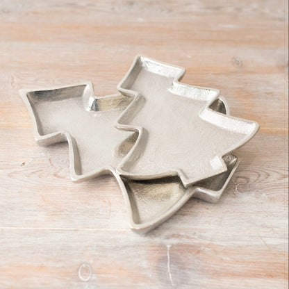 Decorative silver-coloured trays shaped like simplistic Christmas trees, featuring textured surfaces and raised edges.