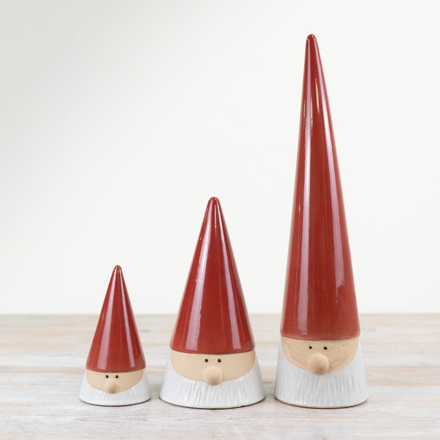 Stoneware Christmas gonk ornaments with tall, glossy red hats and long white beards.
