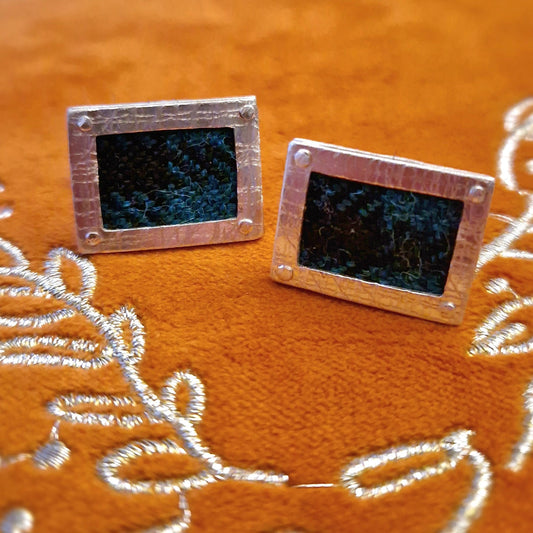 A pair of hallmarked sterling silver cufflinks with a rectangular shape, featuring Black Watch tartan fabric inlay, and secured with sterling silver swivel backs.