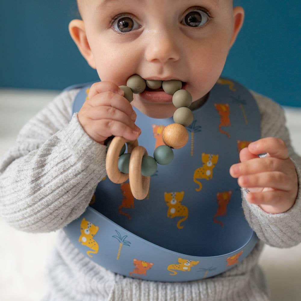 Baby holding a Ziggle wooden teether in Blue Grey