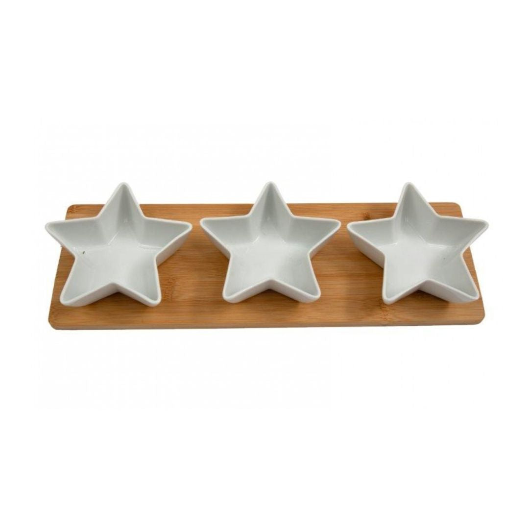 A long, rectangular wooden serving board with three small, star-shaped white ceramic bowls nested inside.