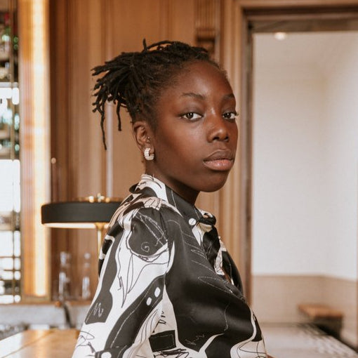 Woman in a monochrome outfit standing at a bar wearing the
MAD Ondulée Hoop handmade in Glasgow from recycled sterling silver – bold, wearable and exclusive in design