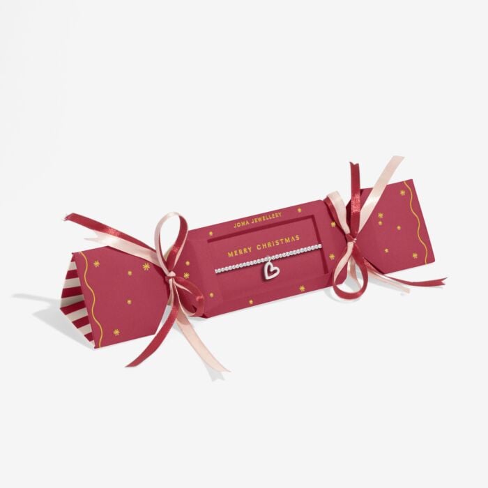 Red Joma Christmas cracker with silver-plated bracelet with heart shaped charm includes pink and red ribbons and MERRY CHRISTMAS text