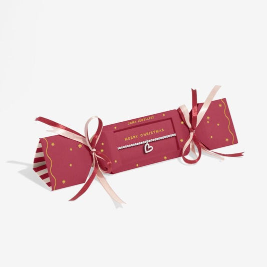 Red Joma Christmas cracker with silver-plated bracelet with heart shaped charm includes pink and red ribbons and MERRY CHRISTMAS text