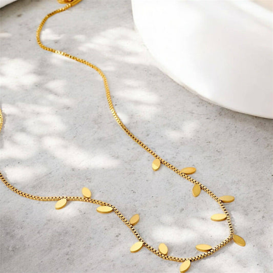 Flax Barn alternating leaf necklace in tarnish resistant PVD gold-plated stainless steel on a display card