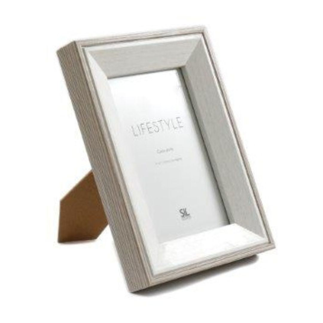 A white wooden photo frame with an antique, rustic finish and decorative detailing
