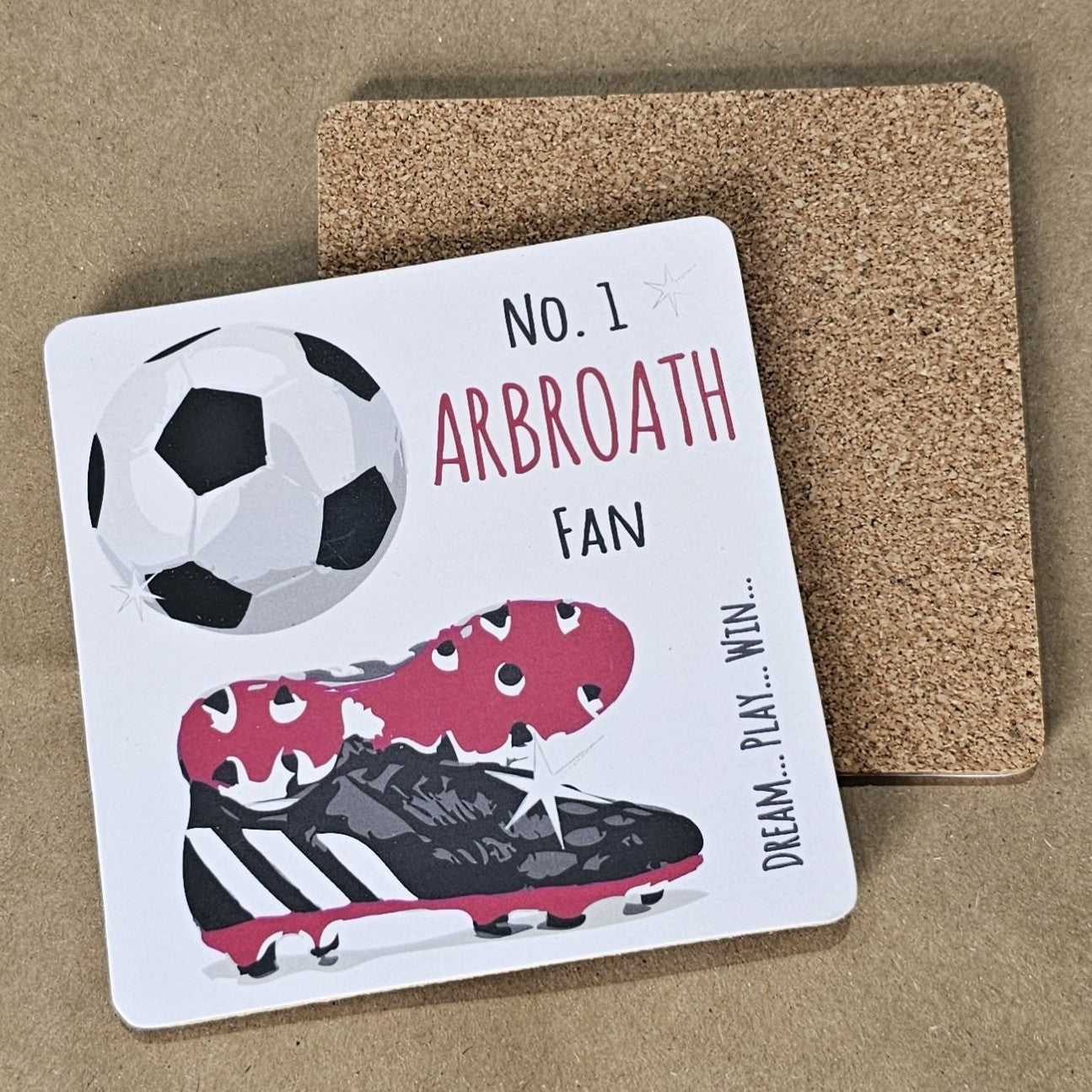 A square coaster with a cork base, featuring a football design with the text 'NO. 1 ARBROATH FAN' and an image of a soccer ball and cleats.