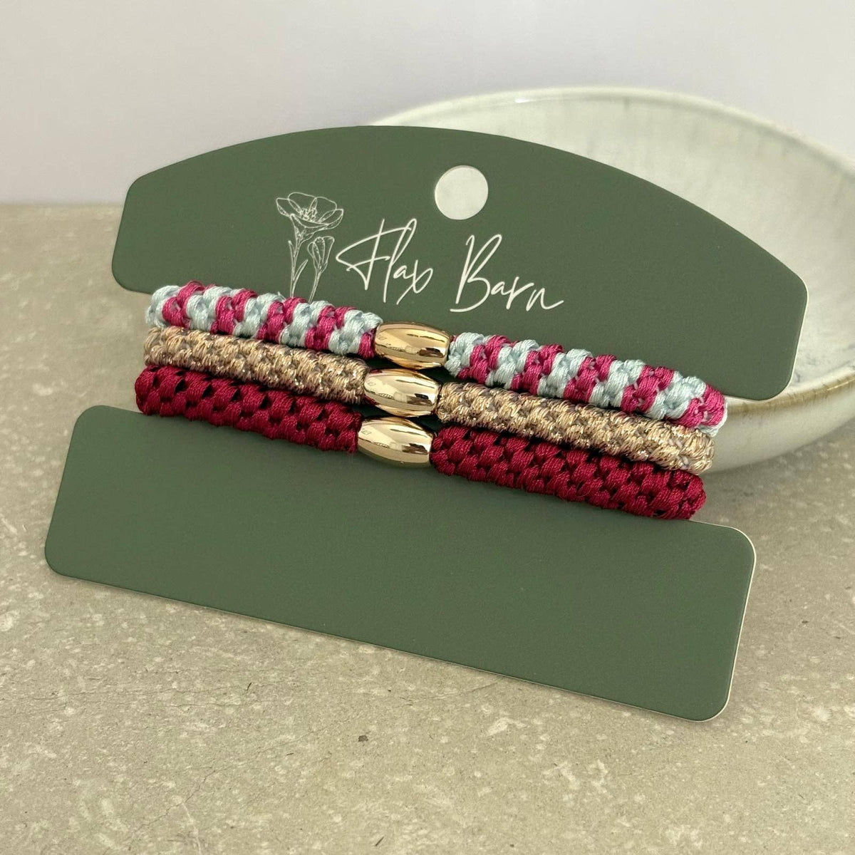 Flax Barn pack of three waterproof elasticated cord hairbands presented on a display card, available in four colourways.