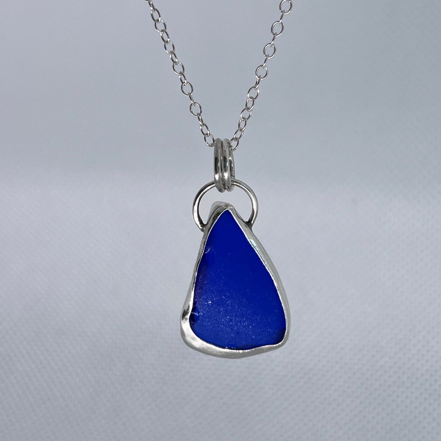 Sterling silver and blue sea glass pendant necklace handmade in Dundee with triangle shape design