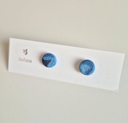 Blue swirl Sefara round stud earrings on a branded card