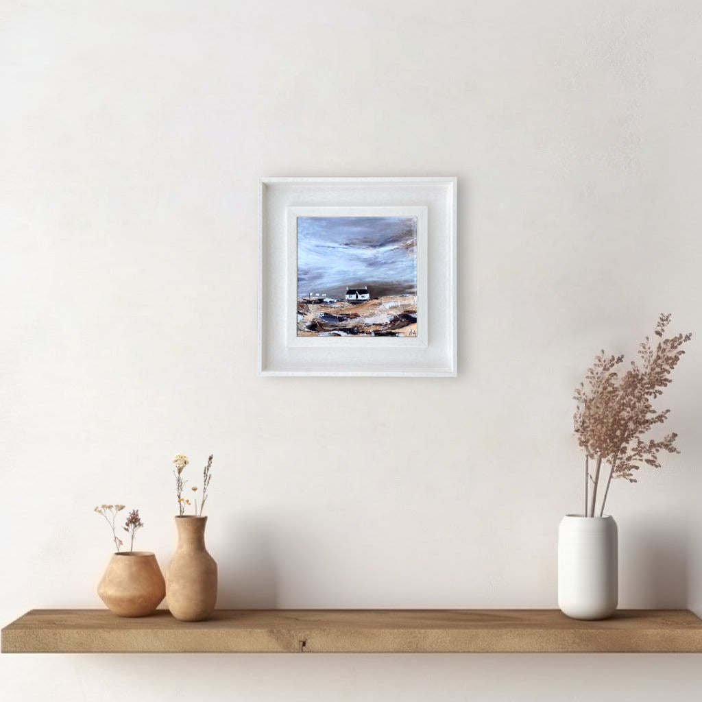 A ceramic tile print of a colourful painting titled 'Blustery Days', showing a small house nestled in the Scottish Highlands, available mounted on natural slate or framed.