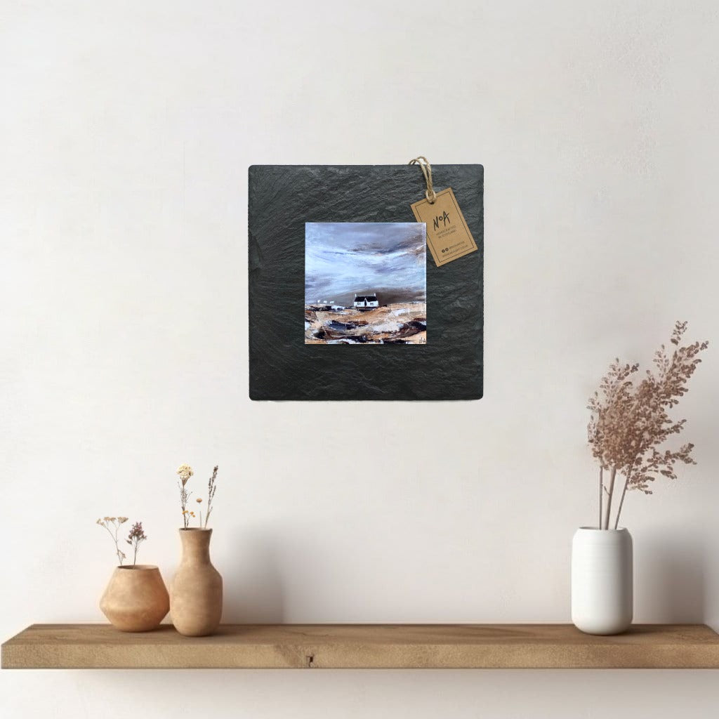 A ceramic tile print of a colourful painting titled 'Blustery Days', showing a small house nestled in the Scottish Highlands, available mounted on natural slate or framed.