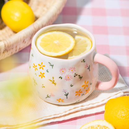 Pink mug with floral design containing lemon slices on a colourful background