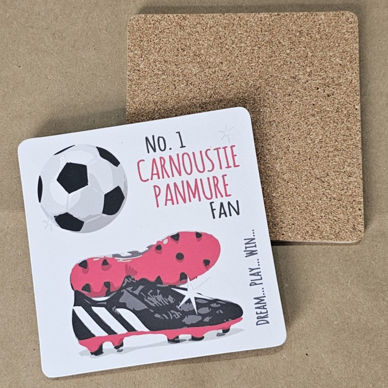 A square coaster with a cork base, featuring a football design with the text 'NO. 1 CARNOUSTIE PANMURE FAN' and an image of a soccer ball and cleats.