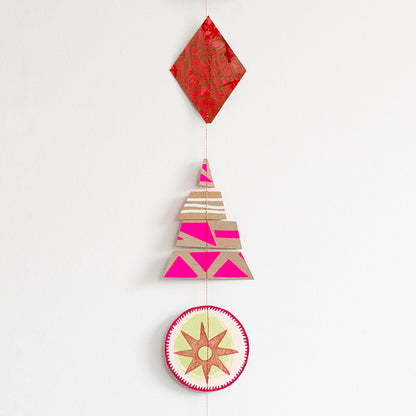 Vertical hanging Christmas garland made of 12 colourful, modern shapes cut from recycled and hand-painted card prints.