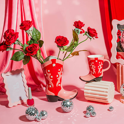 A vibrant red and pink Cowboy Boot Vase with white stars and patterns, designed to resemble a western-style boot.