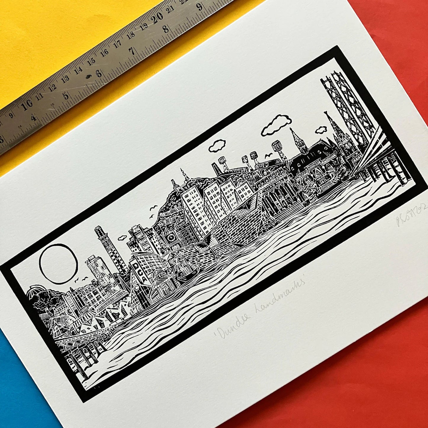 Dundee Cityscape Black and White Lino Print on a colourful background with a ruler at the top
