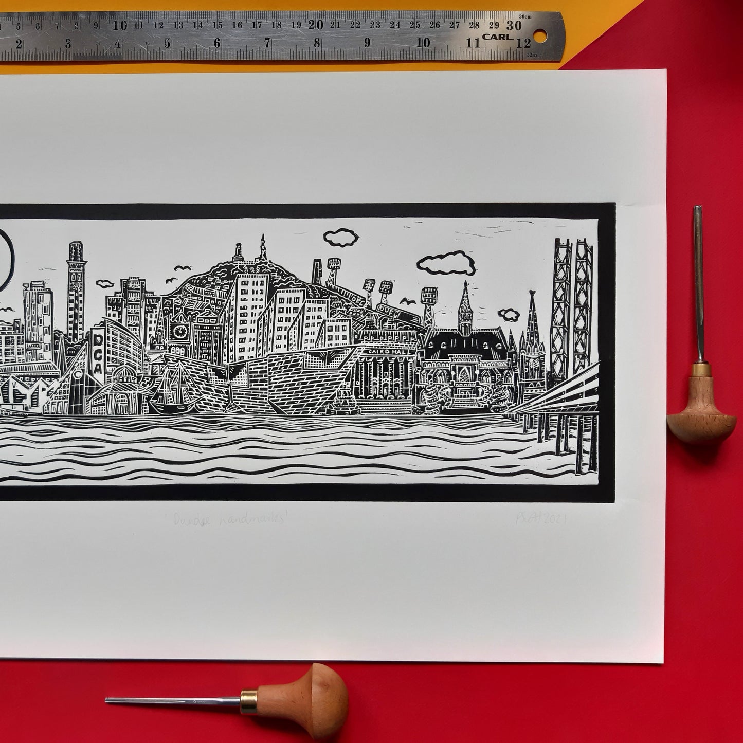 Dundee Cityscape Black and White Lino Print on a colourful background with a ruler at the top