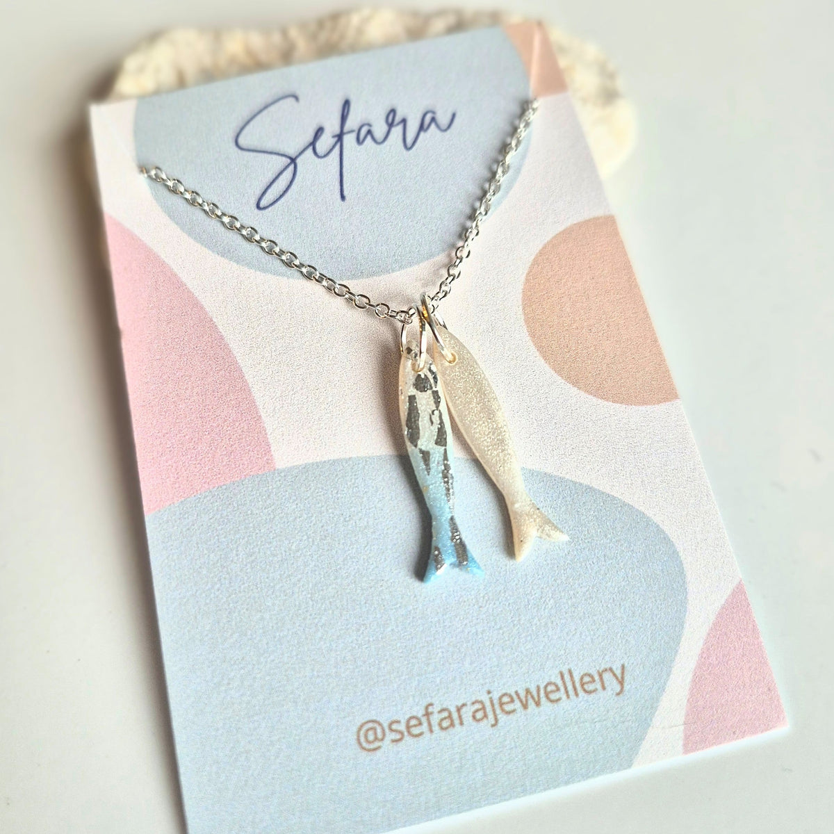 Sefara Jewellery handmade polymer clay sardines pendant necklaces in blue shades, available with two or three sardines on 18-inch silver-plated chains.