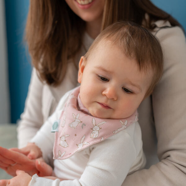 Soft pink baby bandana bib with bunny print, absorbent fleece backing and adjustable poppers