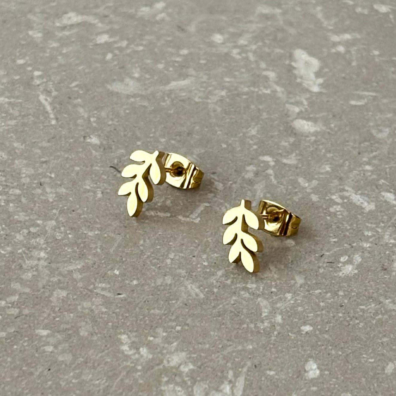 Flax Barn fern stud earrings in tarnish resistant PVD-plated stainless steel on a branded display card