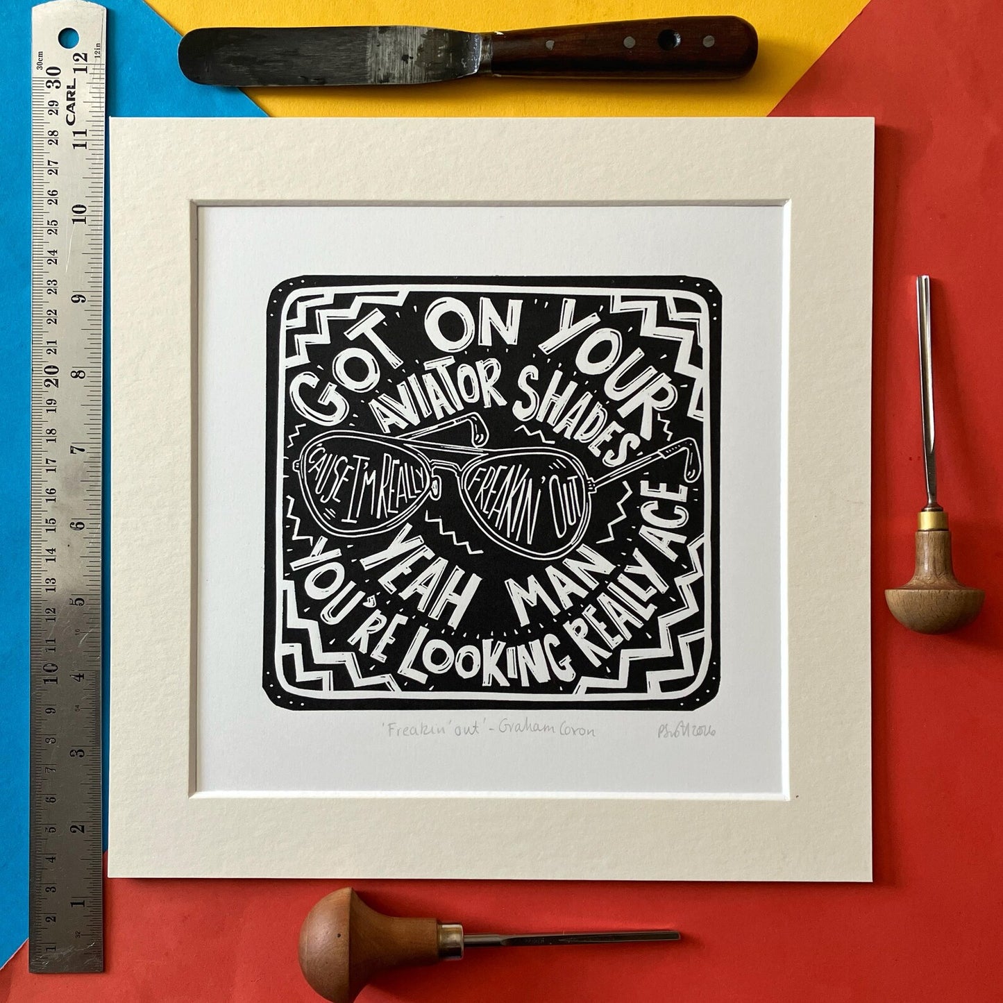 Freakin' Out by Graham Coxon Black and White Lino Print on a colourful background with a ruler at the side
