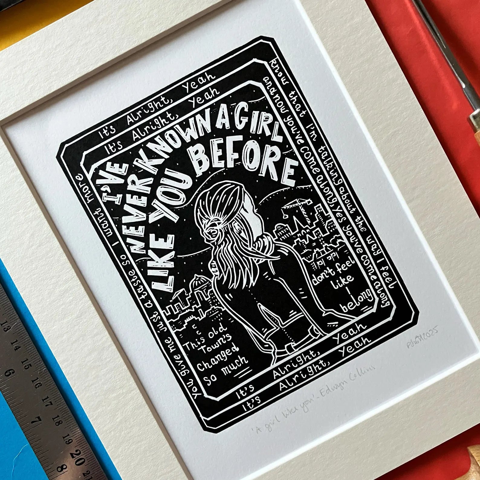 An original black and white linocut print featuring lyrics and imagery inspired by the Edwyn Collins song 'A Girl Like You', mounted on antique white card.