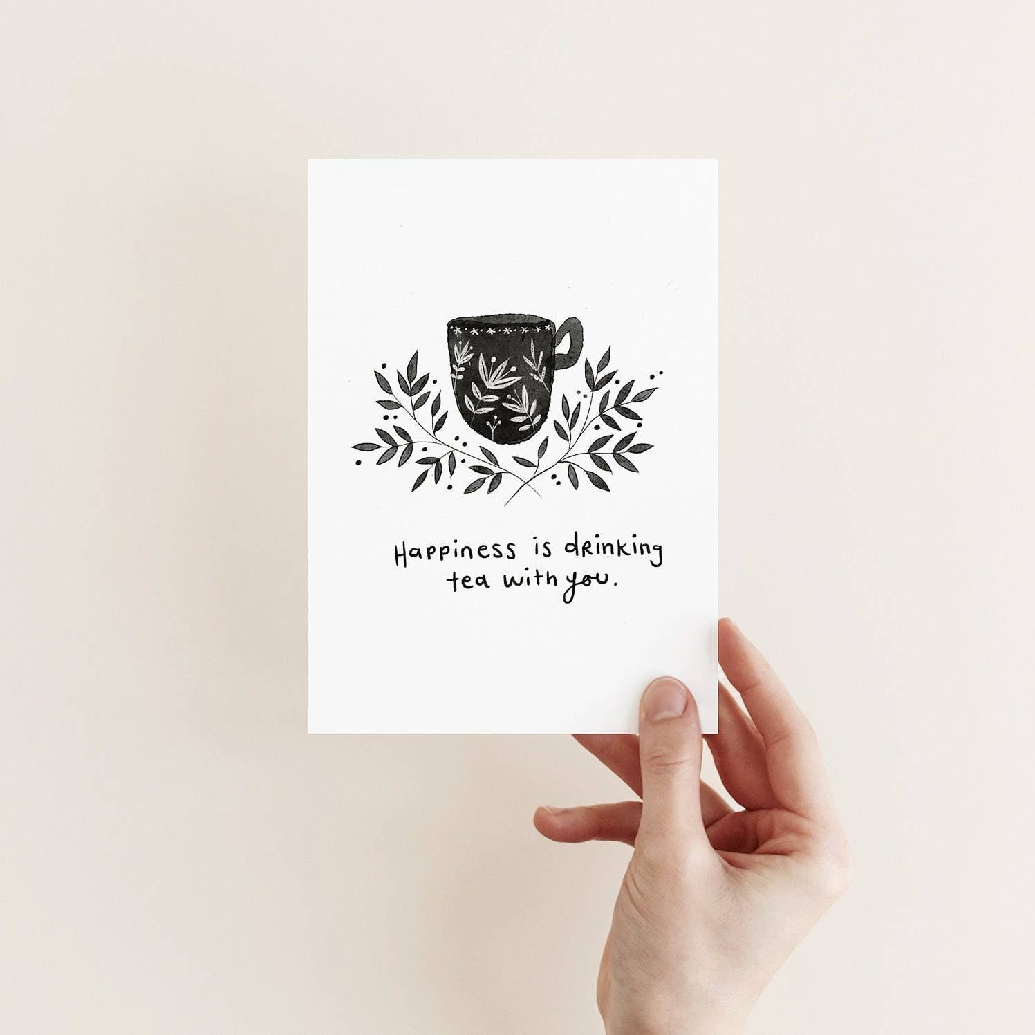Juniper Press greeting card with a monochrome illustration of a tea cup and leaves, and the text 'happiness is drinking tea with you.'.