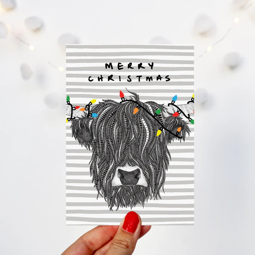 Highland Cow Christmas card featuring hand-drawn festive coo illustration by Kilo Papa Studio with Kraft envelope.
