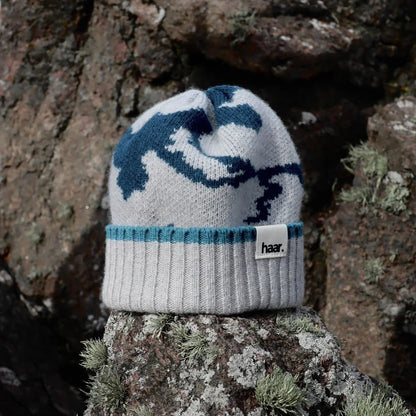 Close-up of a textured lambswool beanie hat, showing the quality of the knit and natural colourway, representing the weathered rocks and sand of the Scottish coast.