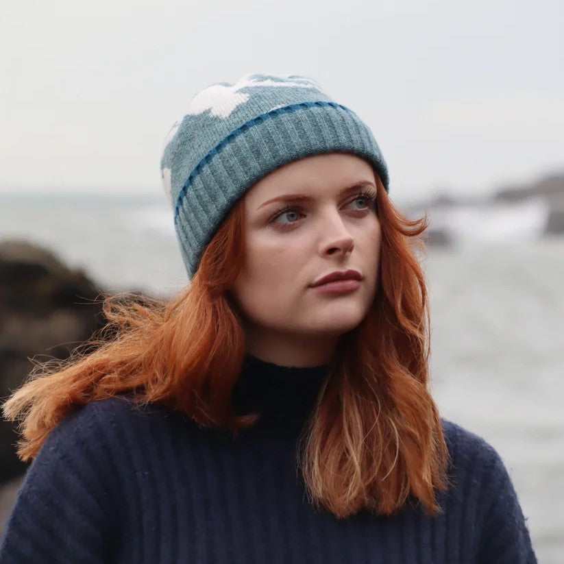 Close-up of a textured lambswool beanie hat, showing the quality of the knit and natural colourway, representing the weathered rocks and sand of the Scottish coast.