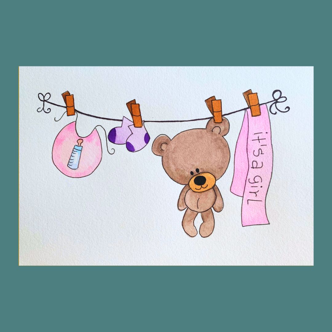 A new baby greeting card featuring a watercolour illustration of a teddy, bib and socks on a washing line with a banner saying 'It's a Girl'