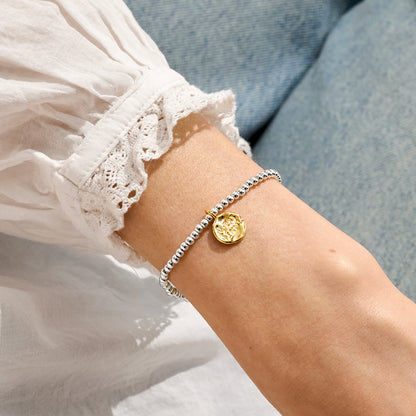 A silver Joma bracelet with a penny charm, packaged in a card that reads 'A Little LUCKY PENNY'.