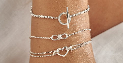 Three Silver Joma Jewellery bracelets on a close up wrist