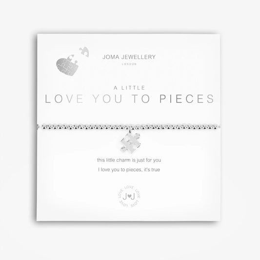 A silver bracelet with a puzzle piece charm, packaged in a card that reads 'A Little LOVE YOU TO PIECES'.