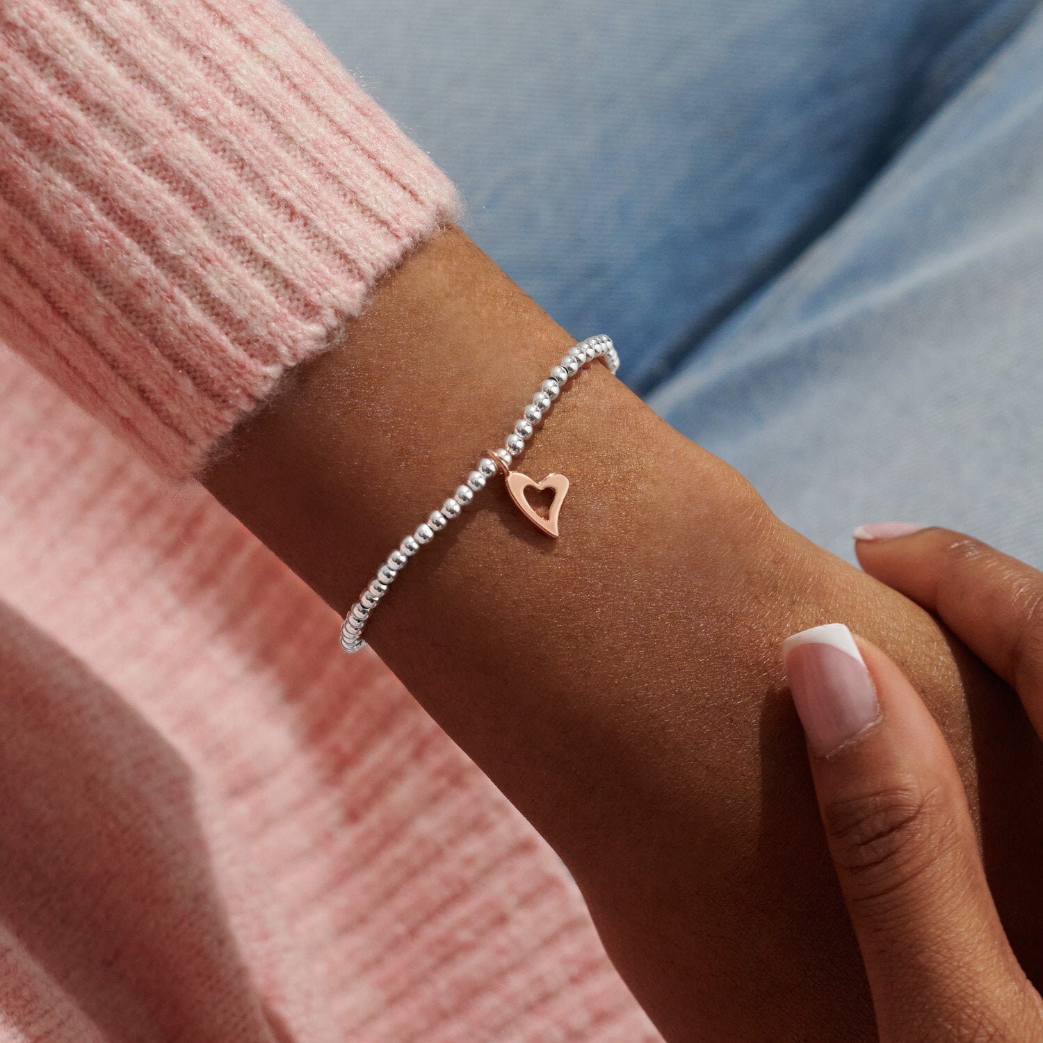 A silver plated stretch beaded bracelet with rose gold heart charm