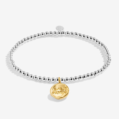 A silver Joma bracelet with a penny charm, packaged in a card that reads 'A Little LUCKY PENNY'.