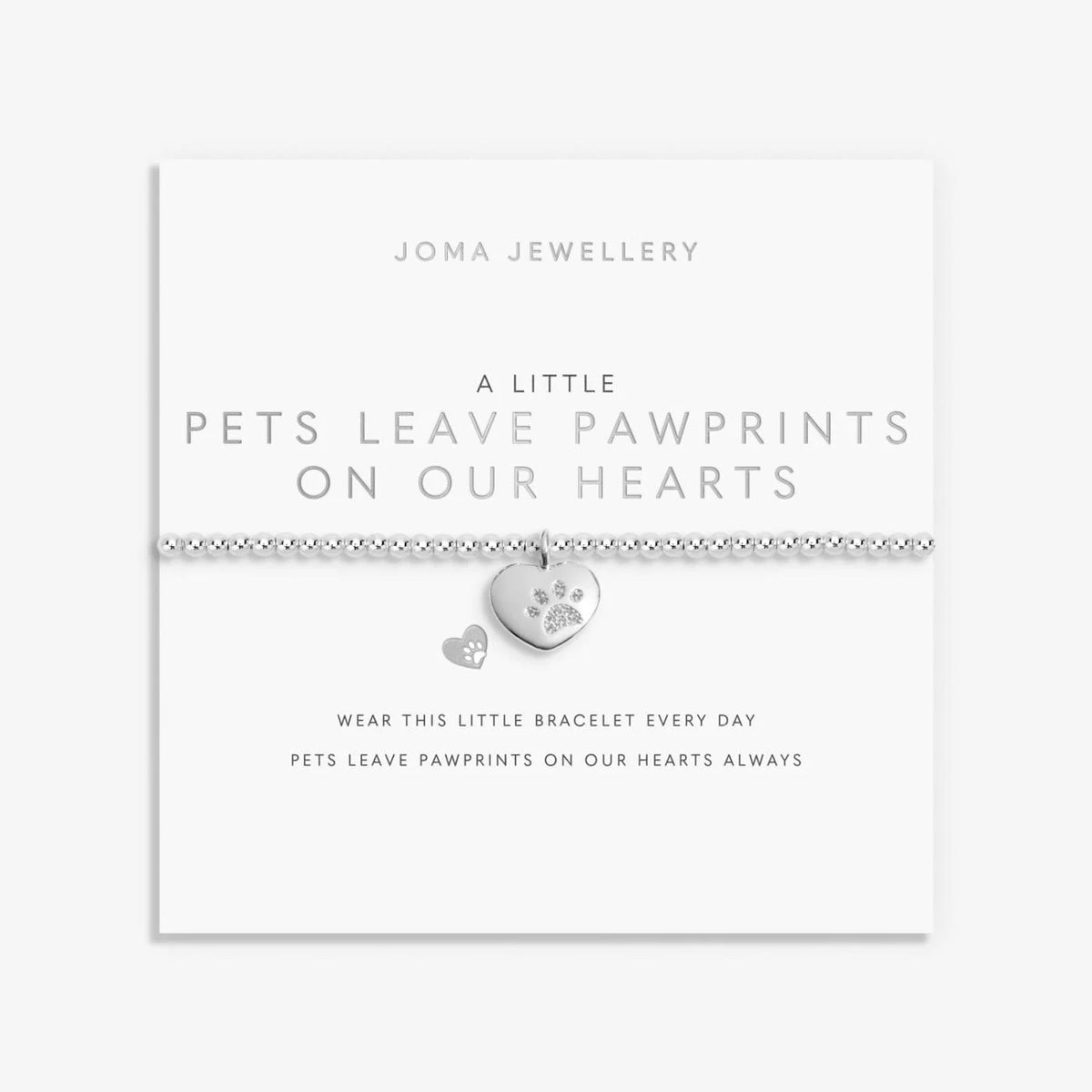 A silver Joma bracelet with a pawprinted heart charm, packaged in a card that reads 'A Little PETS LEAVE PAWPRINTS ON OUR HEARTS'.