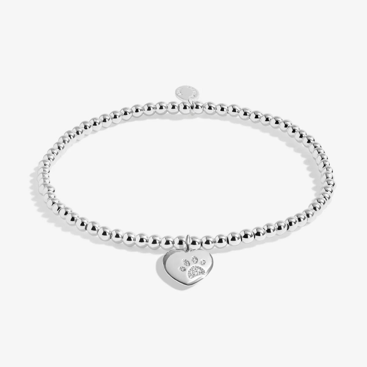 A silver Joma bracelet with a pawprinted heart charm, packaged in a card that reads 'A Little PETS LEAVE PAWPRINTS ON OUR HEARTS'.