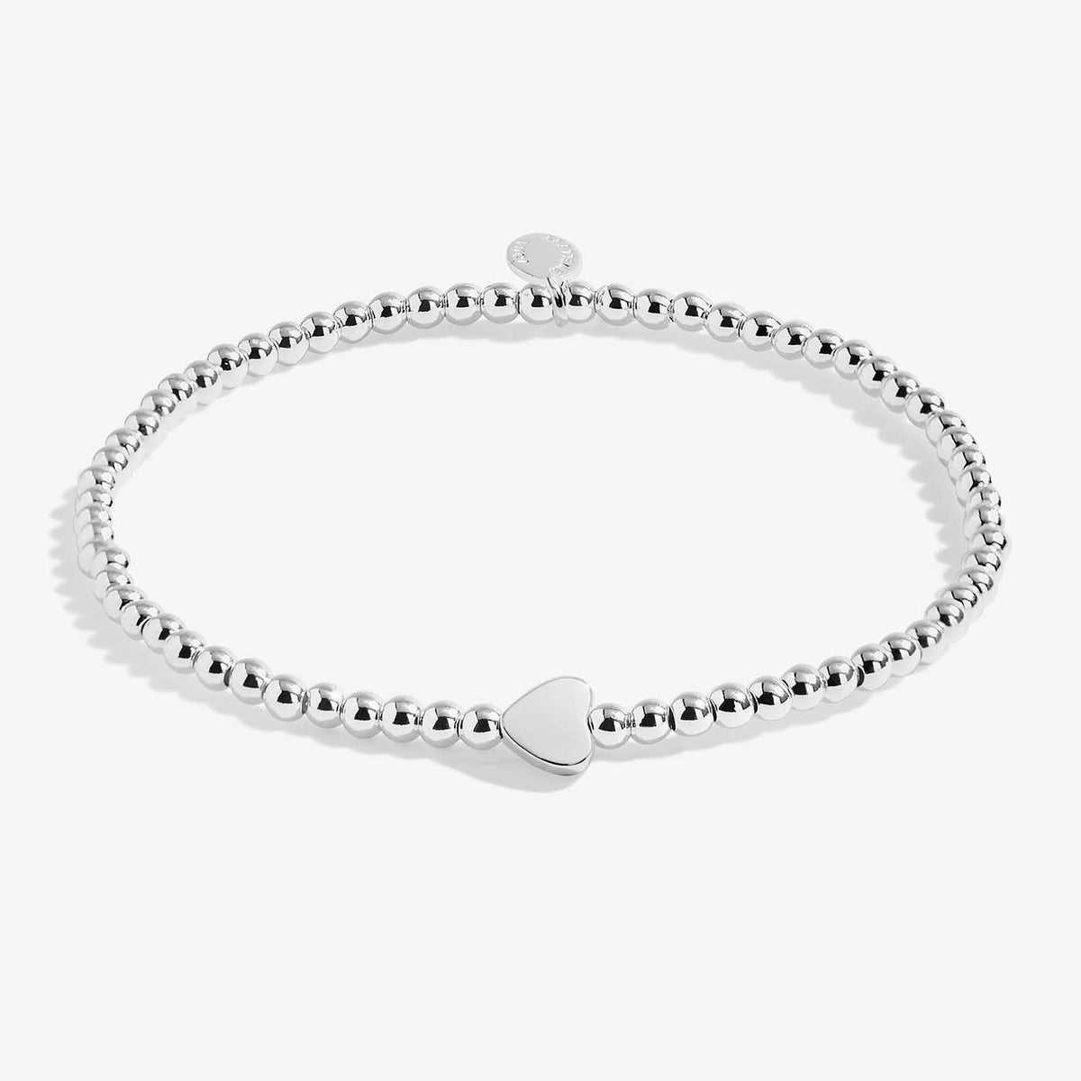 A silver Joma bracelet with a heart charm, packaged in a card that reads 'A Wee BIT O' LOVE'.
