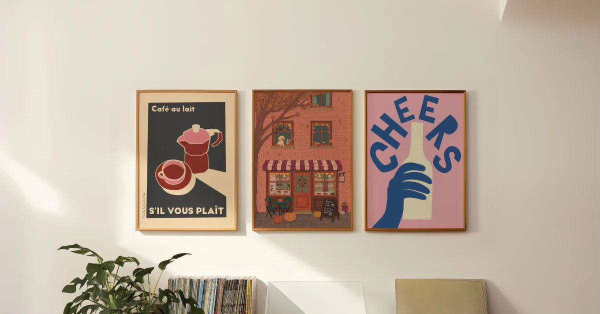 Three framed Lauren Beth Designs posters on a wall with decorative elements.
