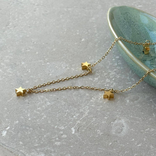 Flax Barn tarnish resistant mini star necklace in PVD gold-plated stainless steel on a branded display card