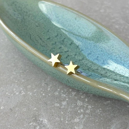Flax Barn mini star stud earrings in tarnish resistant PVD-plated stainless steel on a branded display card