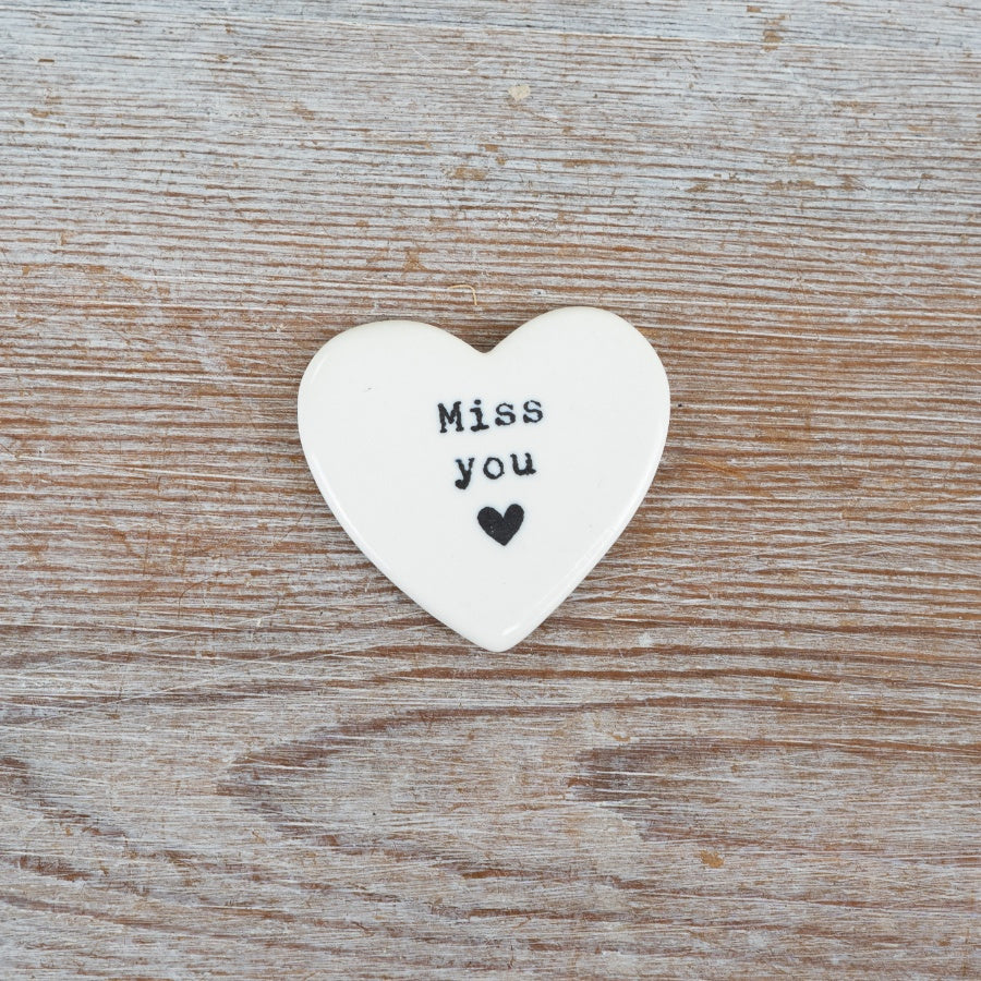 Heart-shaped white ceramic token with 'Miss you' text