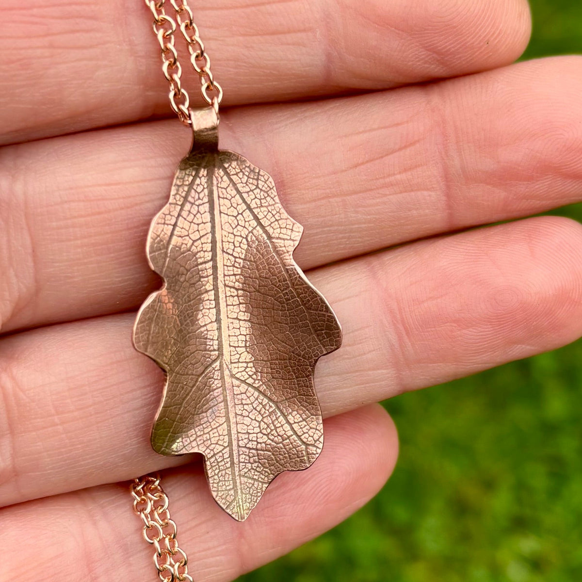 Rowan Berry Jewellery handcrafted copper oak leaf necklaces in three styles: simple leaf, sculptural statement leaf and oak leaf with sterling silver tiger's eye acorn.